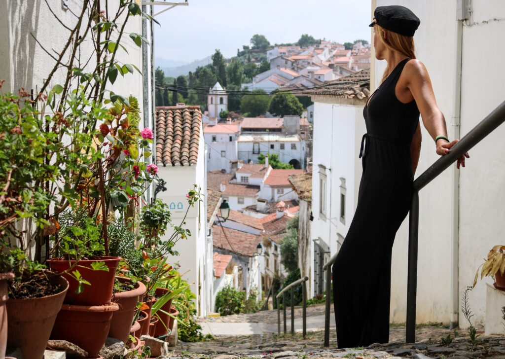 girl on staircase with white wash town in most instagrammable places in portugal