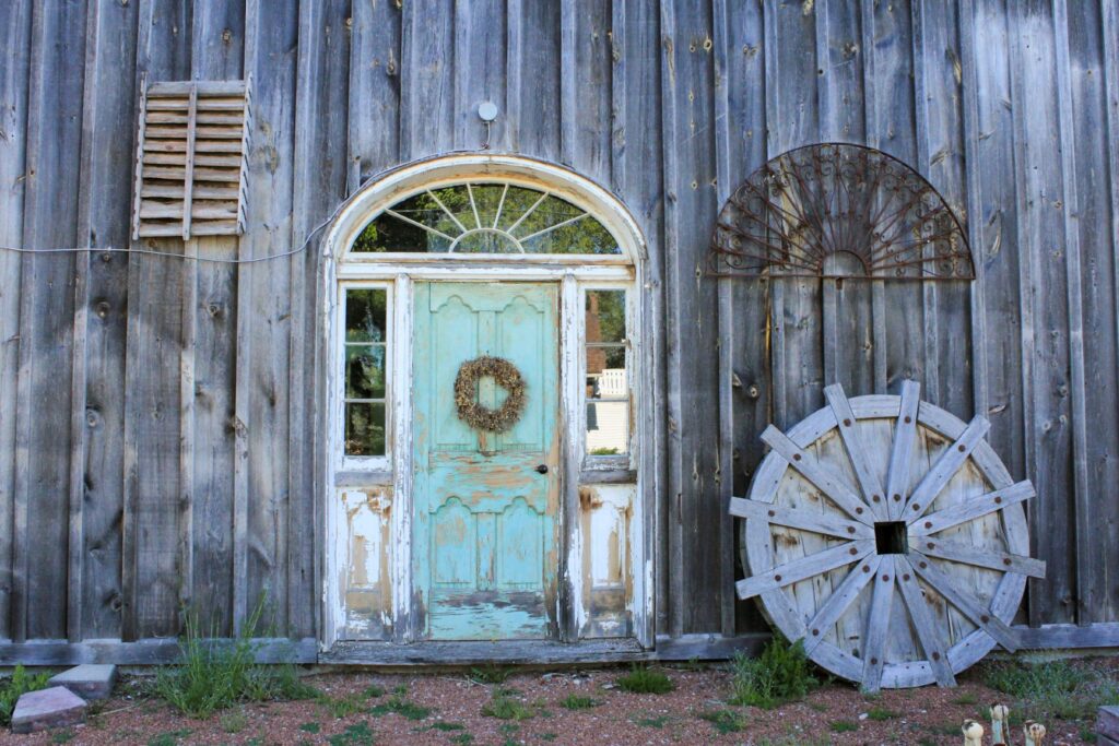 gray building with vintage blue door and wagon wheel in best town in ontario