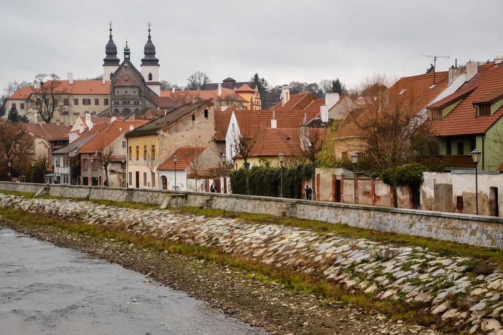 river with town alongside with red rooftops anc church steeple in Czech Republic UNESCO sites 