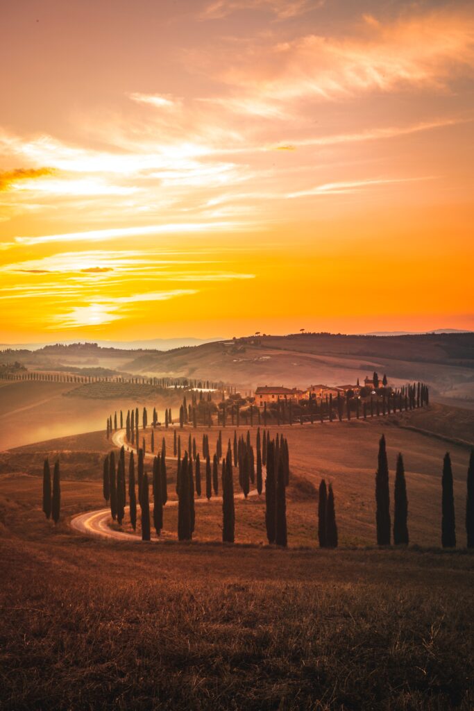 yellow sky at sunset over rolling hills in pienza