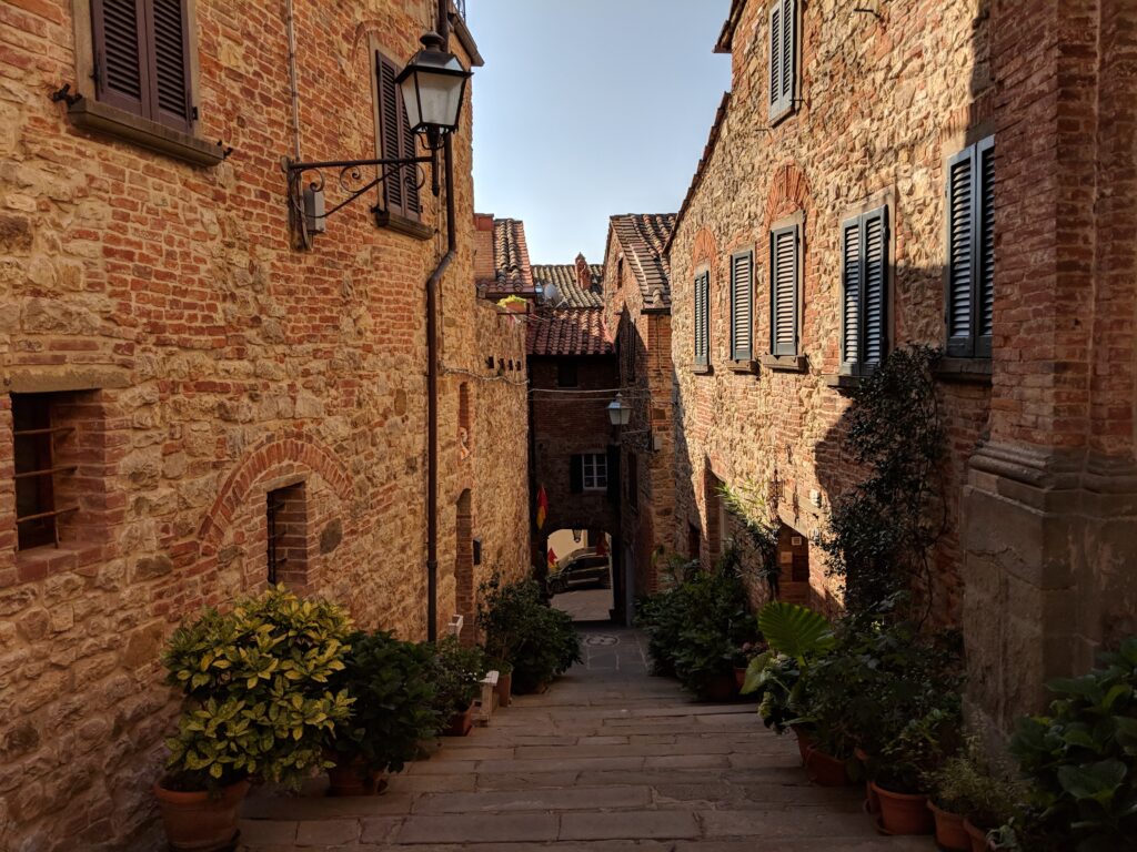 tiny alleyway with red brick houses in tiny town in tuscany