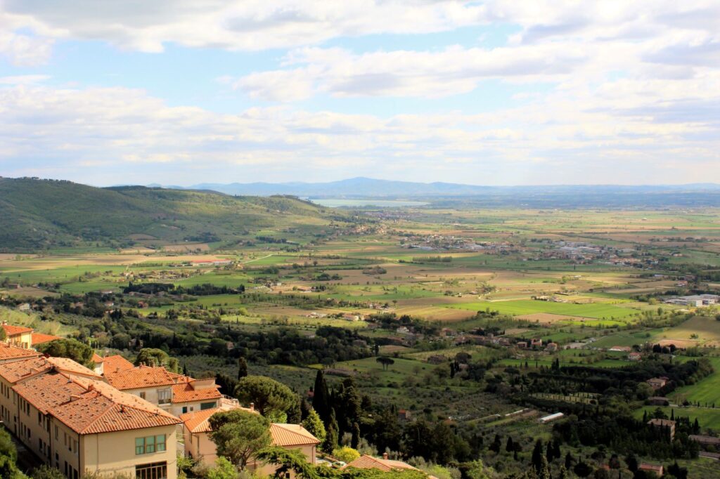 view of farmhouse valley and lake in cortona italy