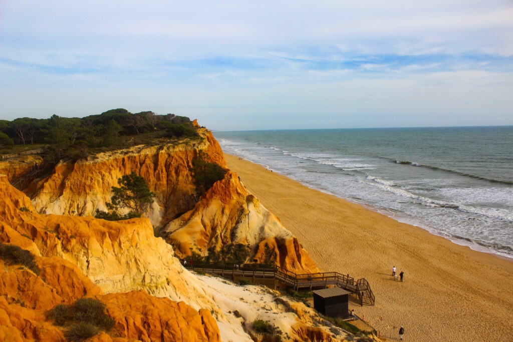 red cliffs overlooking sea and beach in algarve portugal