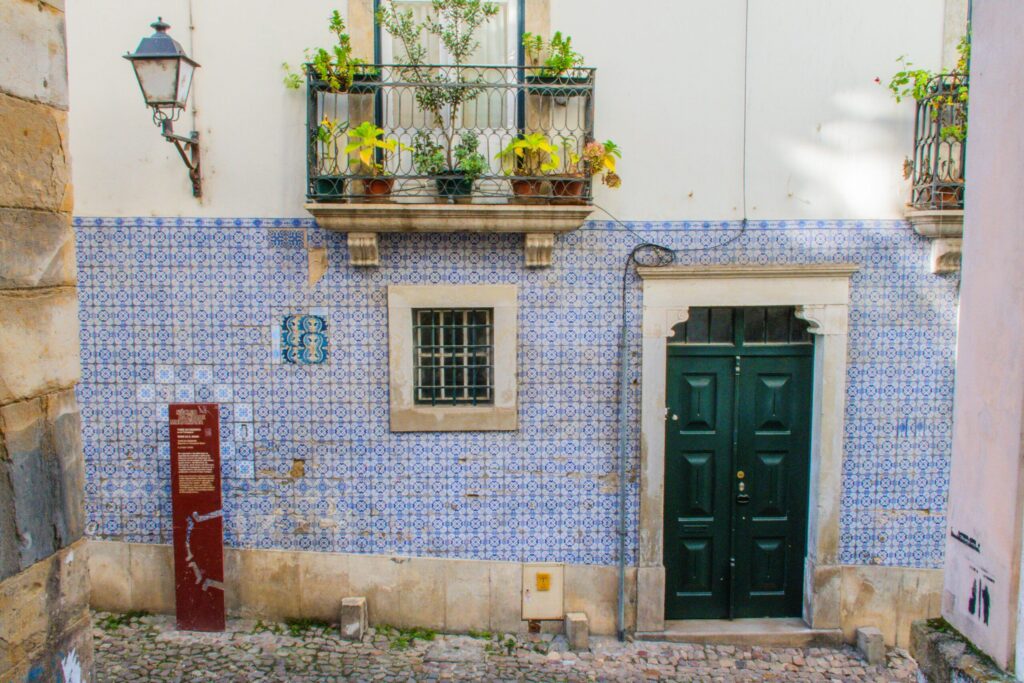 blue tile building with green door and iron balcony on coimbra what to see itinerary
