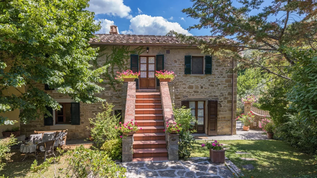 brick stone villas for rental in cortona italy with steps shutters on window and trees 