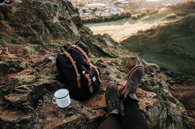 mountain with backpack and coffee mug