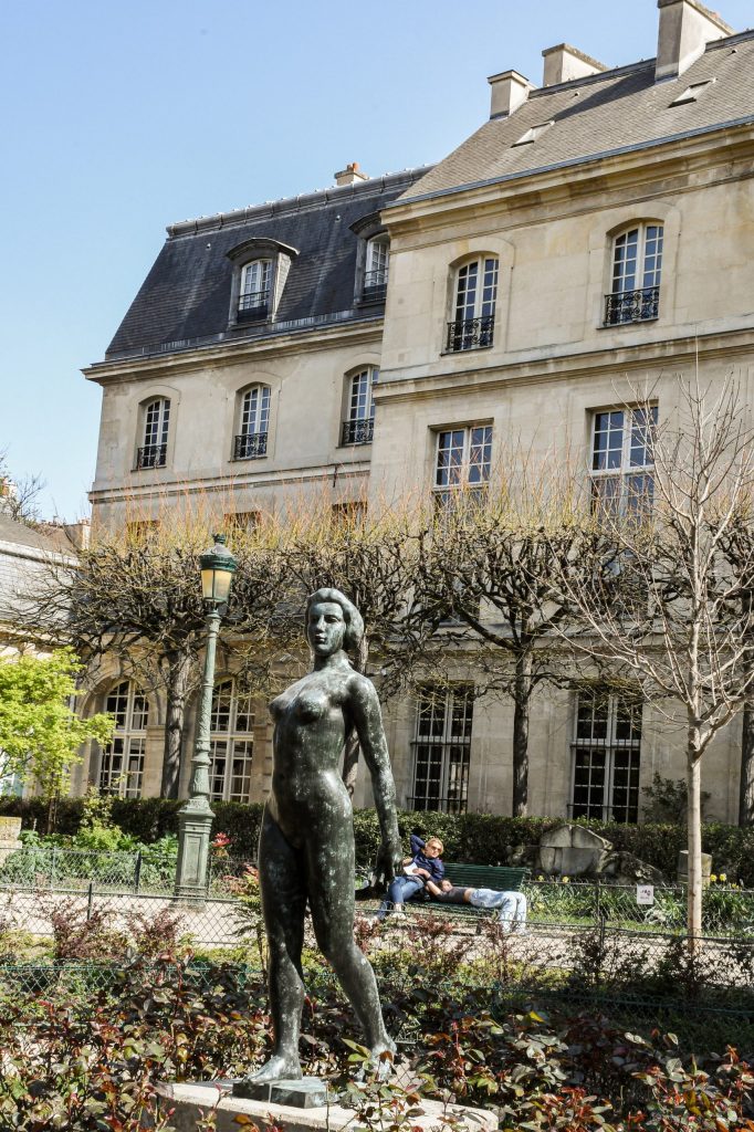 statue with trees and building in paris garden