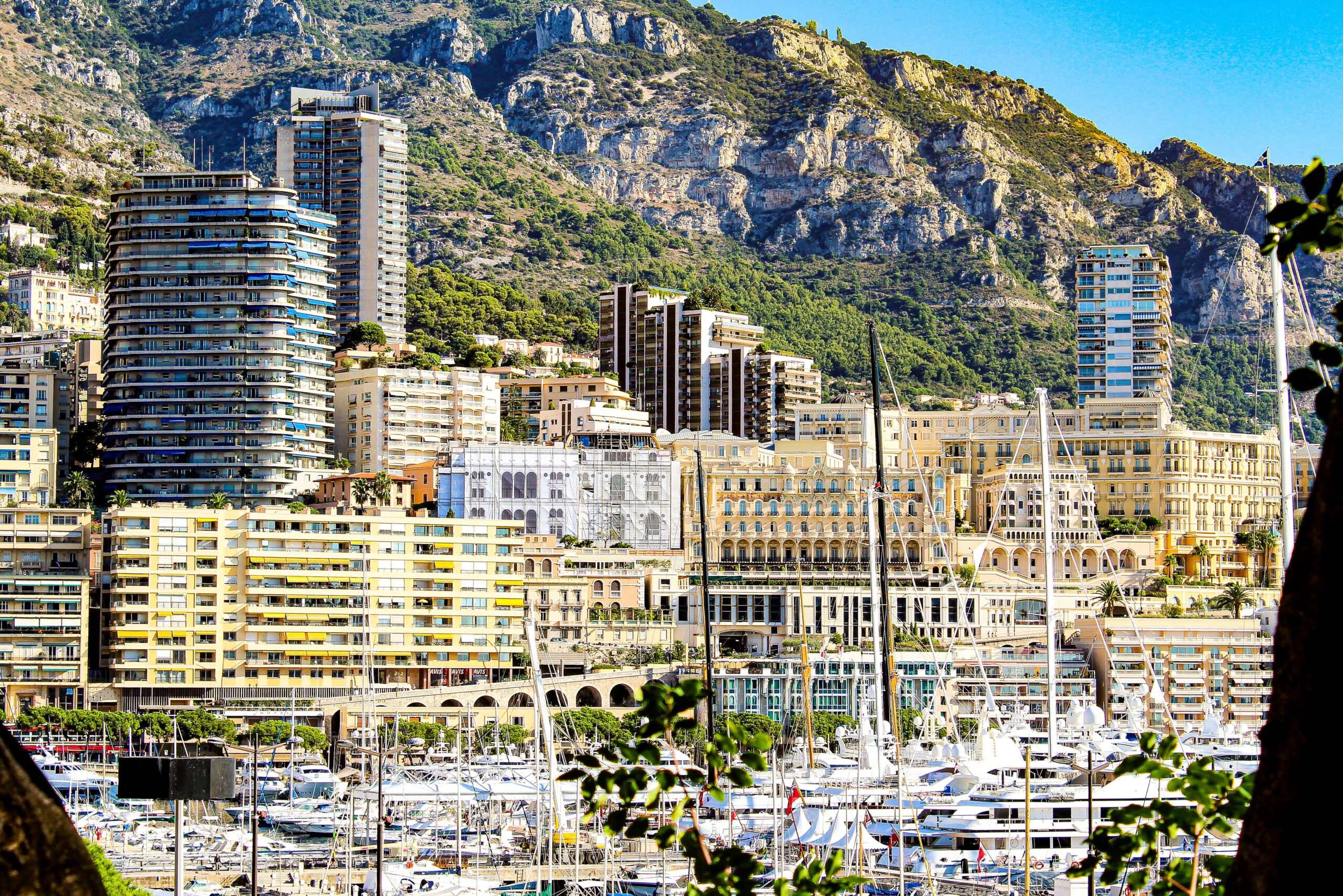 yachts in bay, high rise buildings agains mountain in a day in monaco