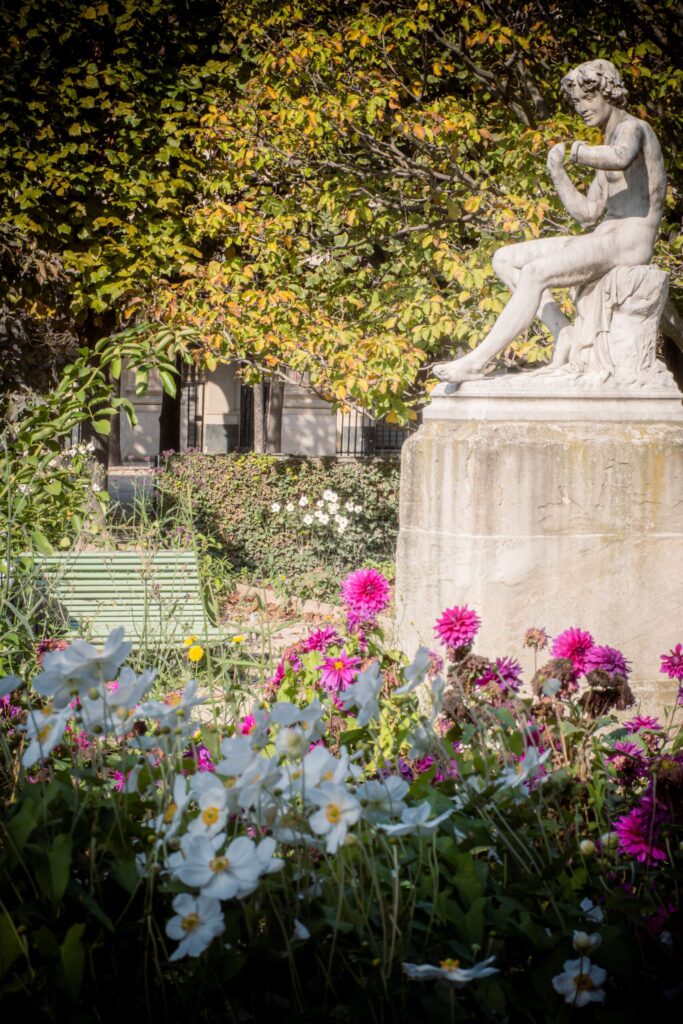 statue with flowers in most romantic places in paris