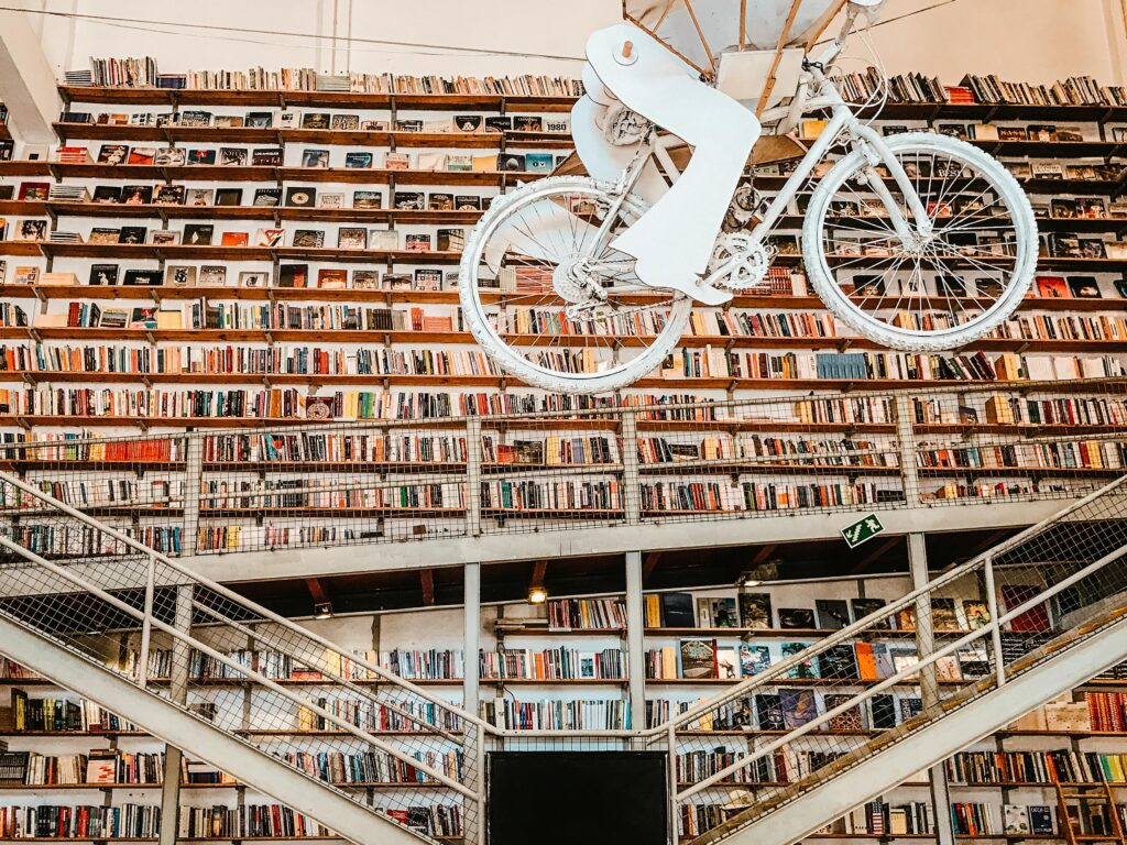 books lined on bookshelves with iron walkway in lisbon 