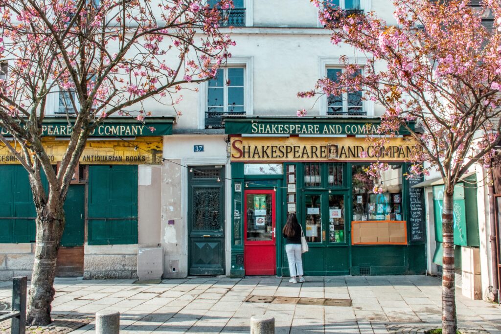 girl at book shop with spring trees on paris solo trip