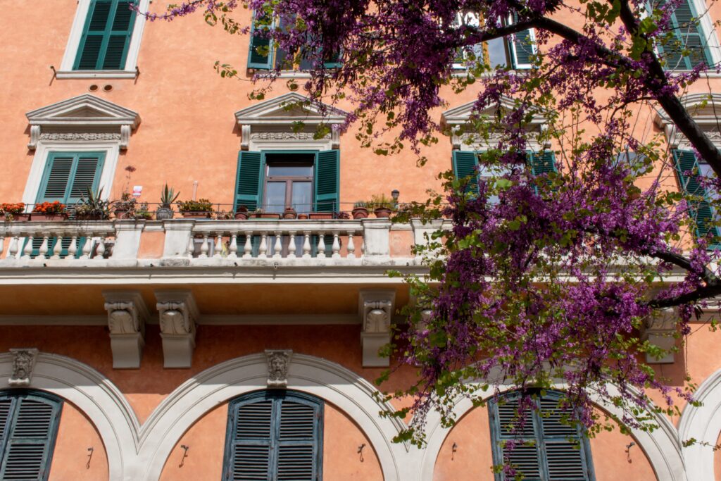 orange building with pink flowers when visiting rome in spring