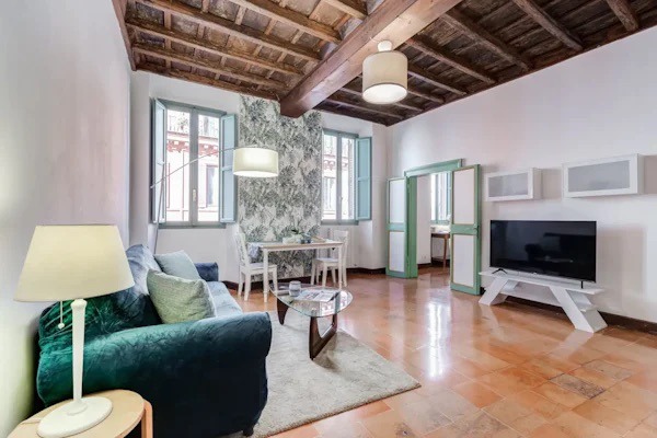 green sofa, beamed ceiling in rome apartment