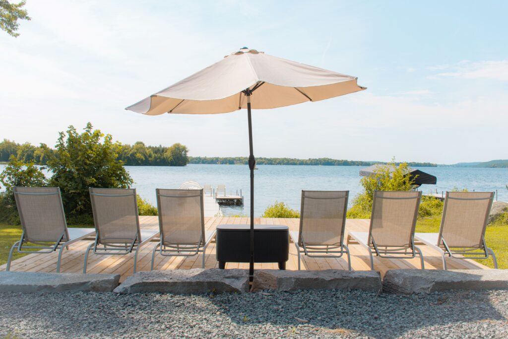 6 lounge chairs with umbrella and lake at Ontario Airbnb
