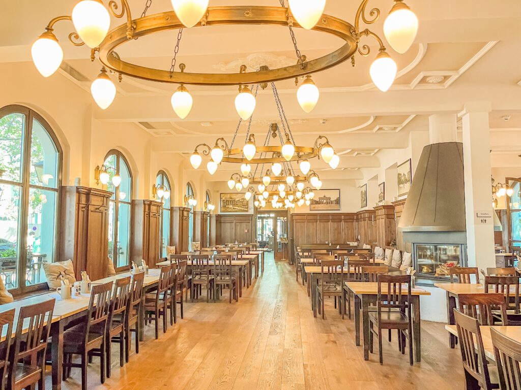 inside a traditional german restaurant in berlin with fireplace, wood tables and chairs 