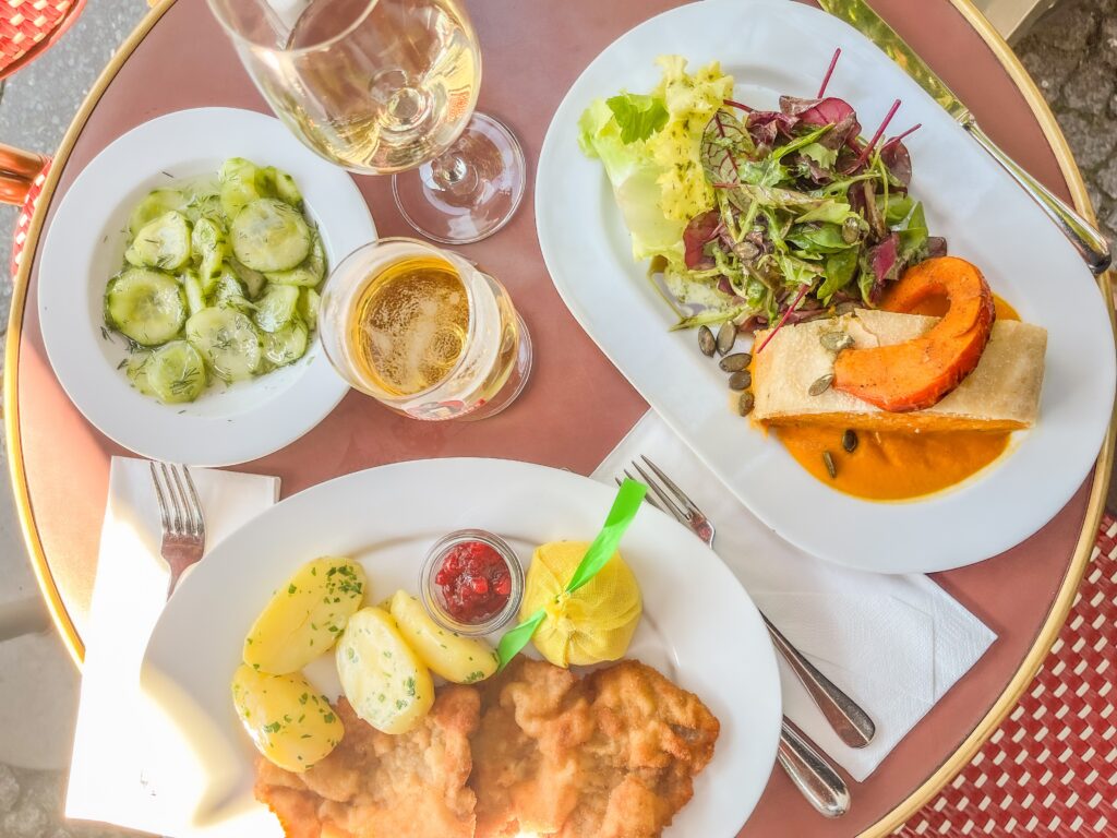 table of german food at berlin restaurant with schnitzel, salad, beer