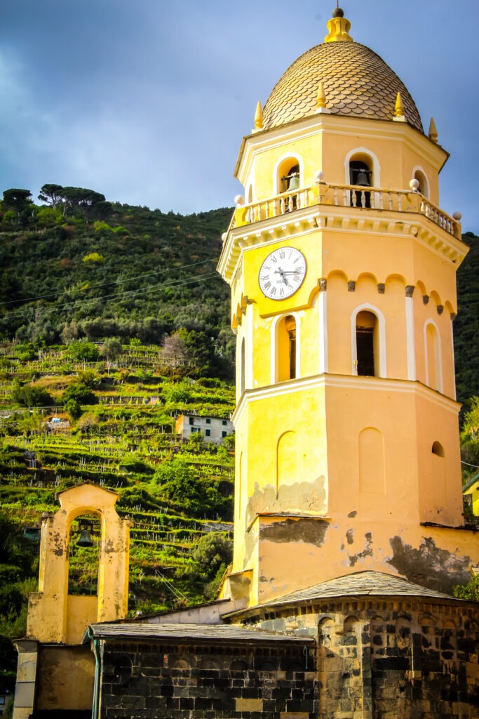 yellow clock tower with hill on cinque terre from florence day trip