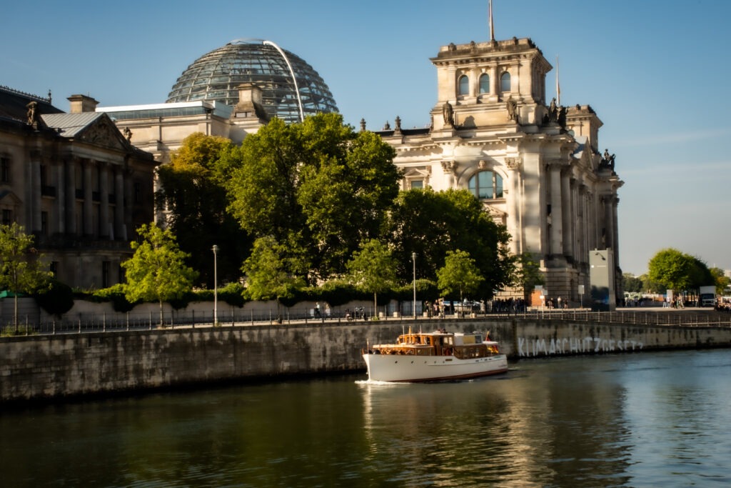 boat and buildings on riverbank on what to do in berlin on a sunday