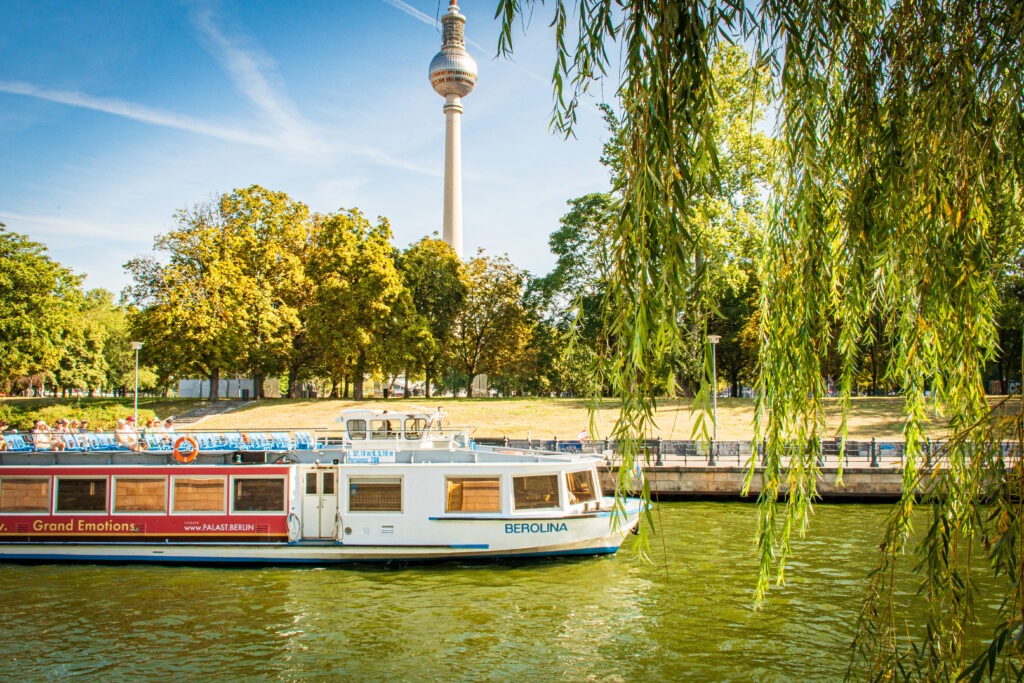 spree river with boat and tv tower on what to do in berlin on a sunday