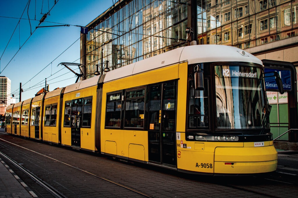 yellow street car with building on why is alexanderplatz famous