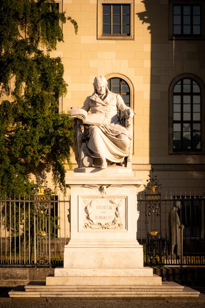 stone statue of man with book on unter den linden street in berlin 