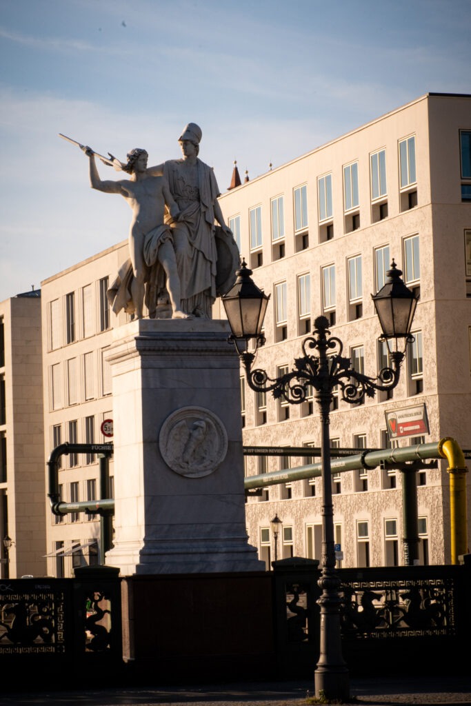 statues on bridge on unter den linden with lamp post and building