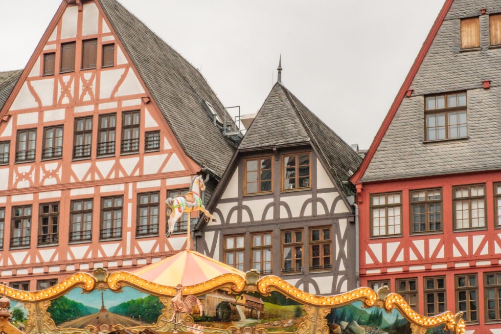 top of carousel and half timbered buildings in christmas markets in frankfurt