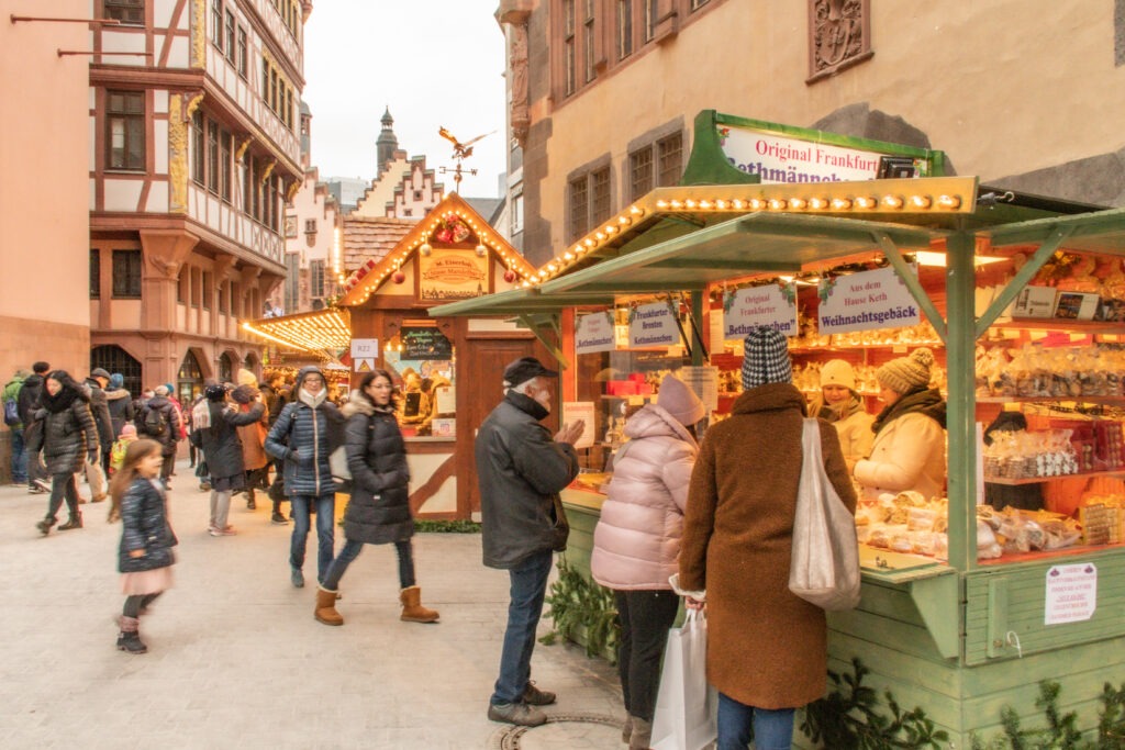 people at market stall at christmas market in frankfurt germany