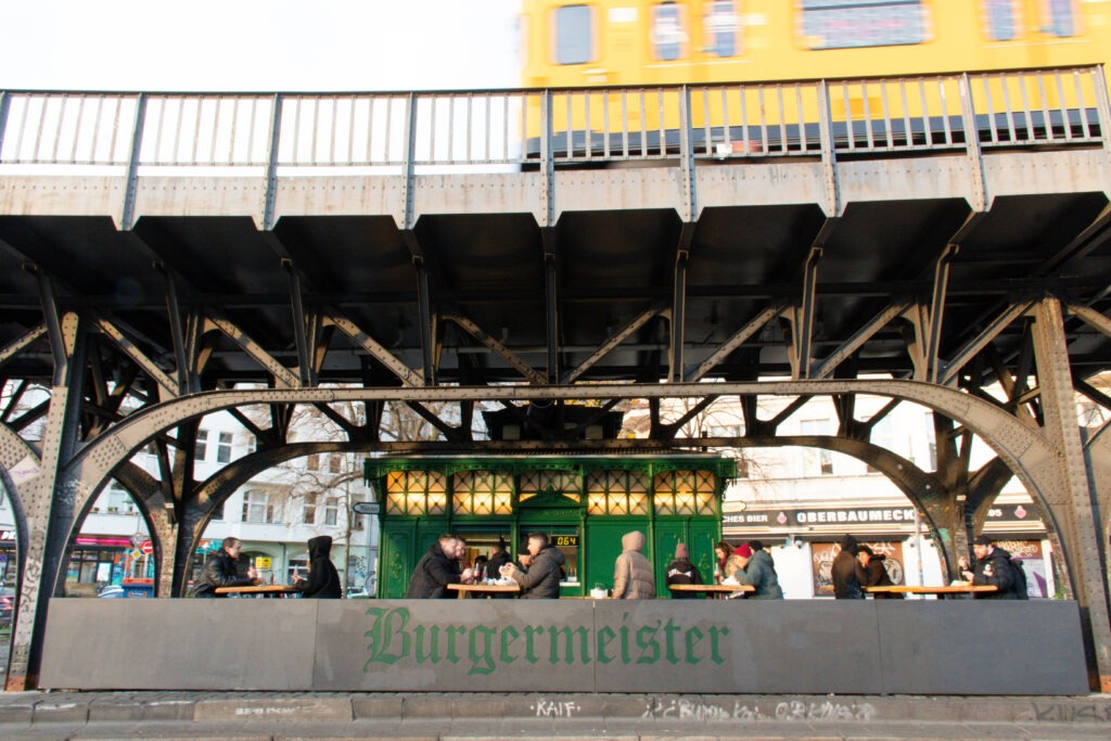 yellow subway underneath a green restaurant on a food tour in berlin