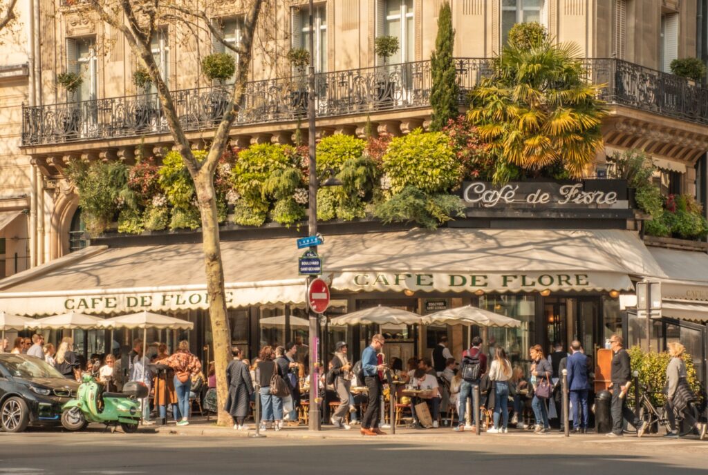 outdoor cafe with people sitting in paris when comparing paris and berlin