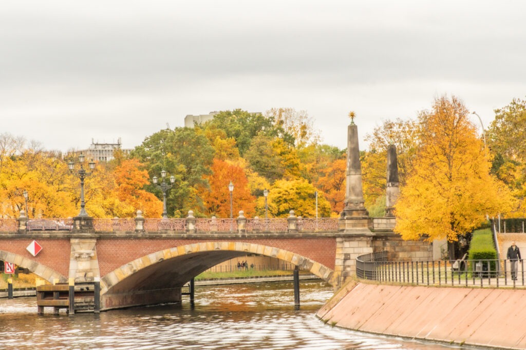 red brick bridge with autumn foliage trees on best boat tours in berlin