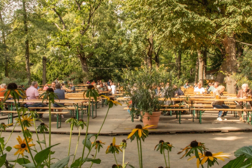 beer garden with picnic tables and chairs under trees as one of the tiergarten things to do