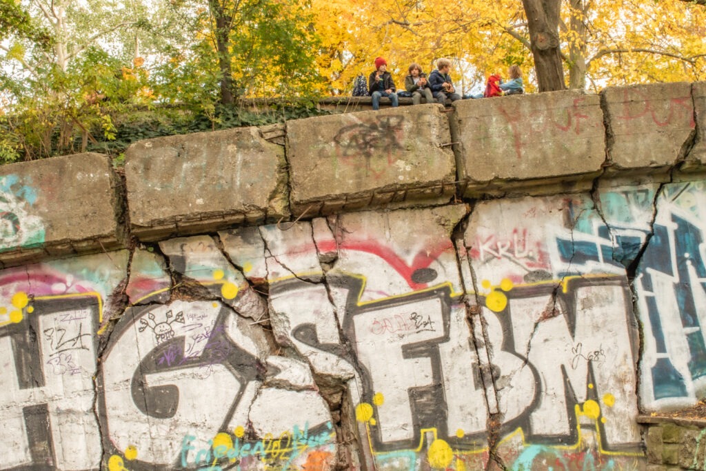 ww11 bunker with graffiti with kids sitting on top as a berlin viewpoints of the city 