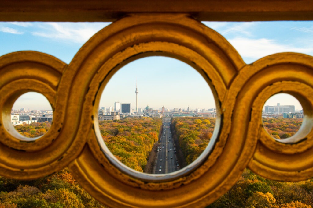 berlin view of trees in autumn and tv tower through peekhole