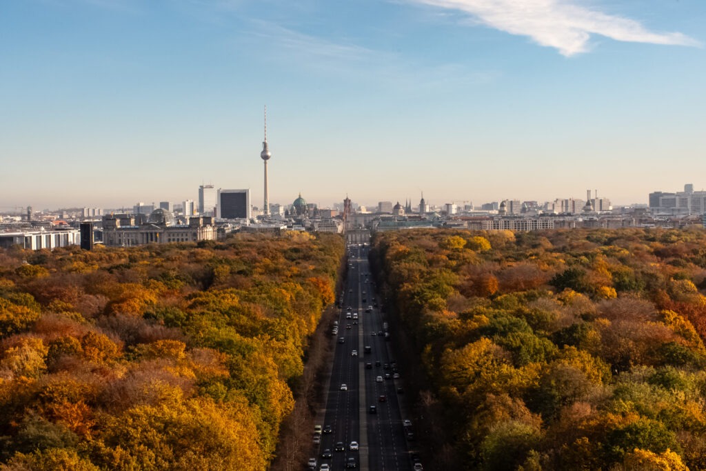 berlin vantage point of road, trees in autumn and tv tower with berlin skyline