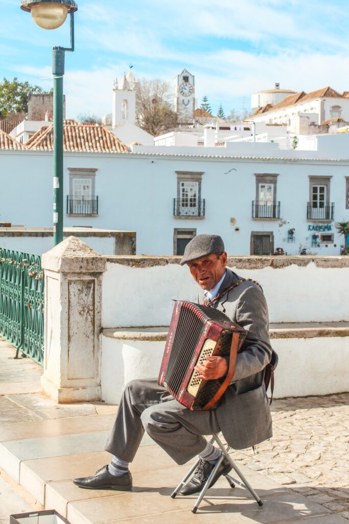 man playing accordion on bridge as best things to do in tavira portugal