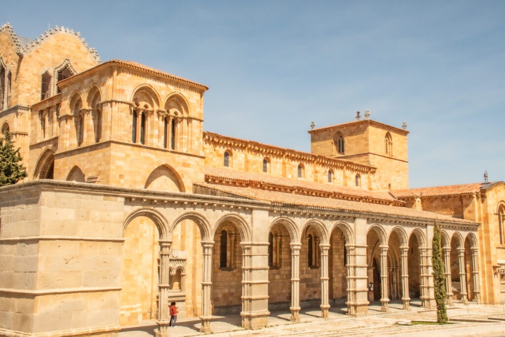 square with tall archways with church towers in avila spain