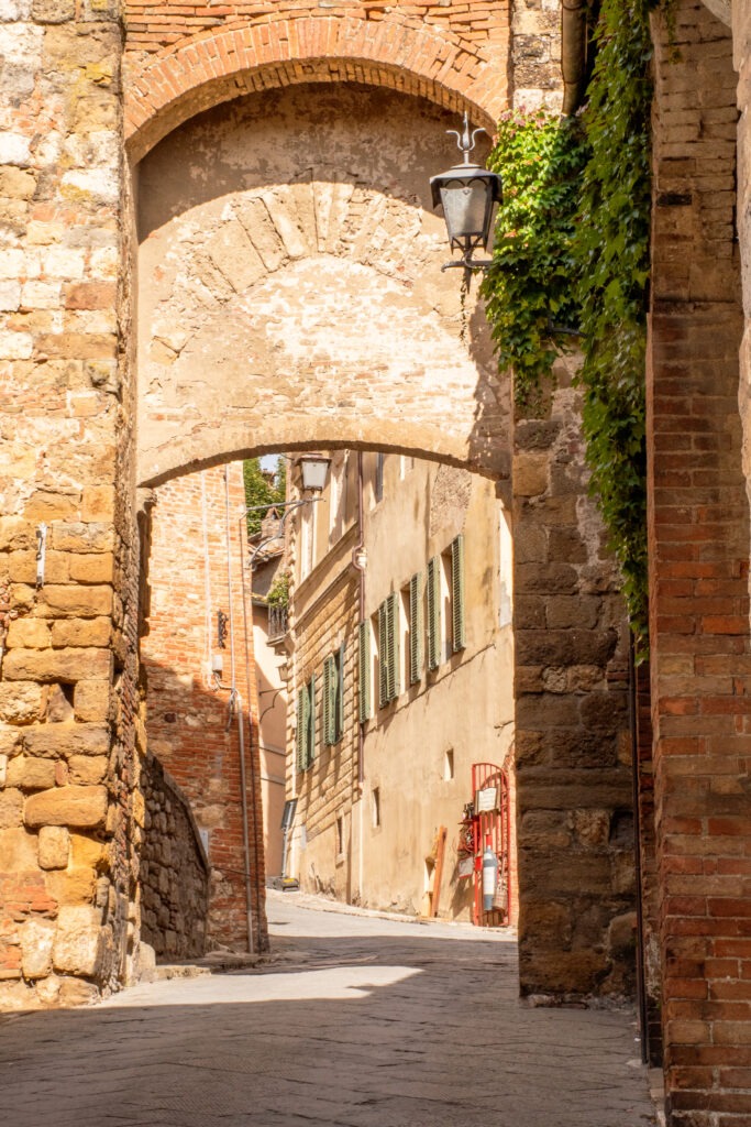 stone archway leading uphill to a street in what to see in montepulciano