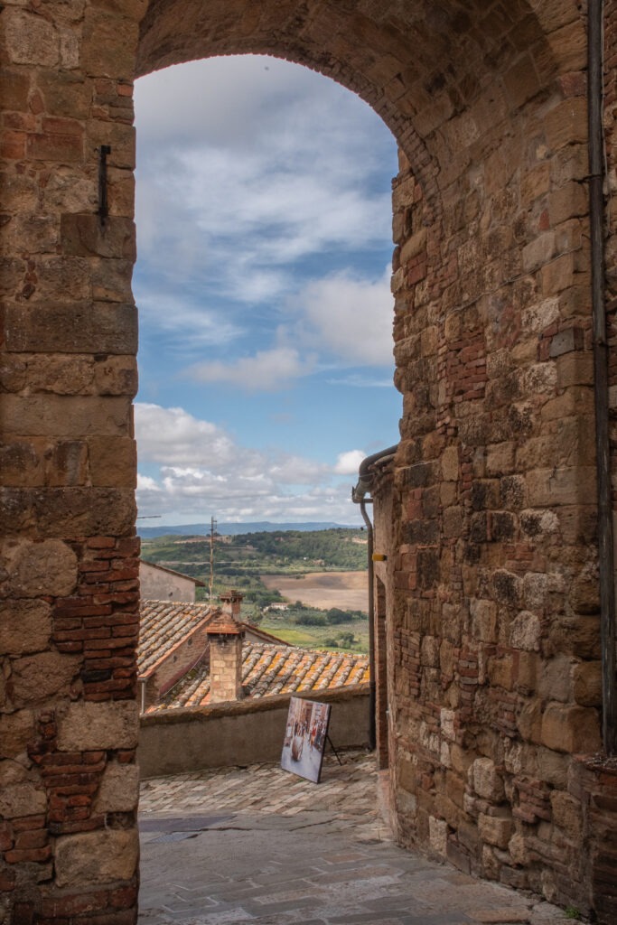 stone archway view view to countryside in montepulciano with blue sky