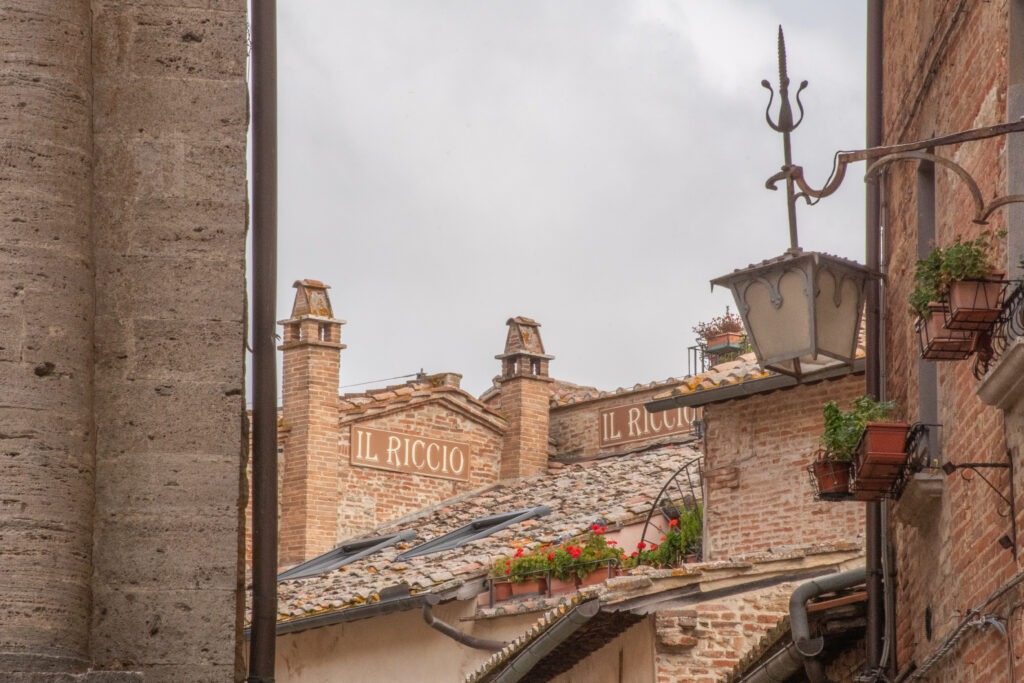stone building rooftops with lantern and sky in montepulciano italy