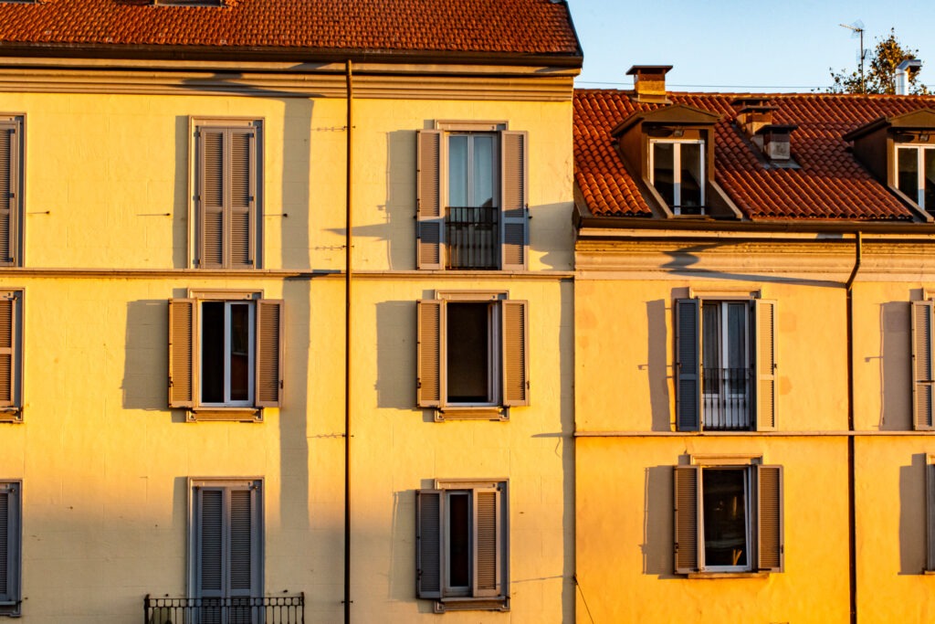 yellow buildings with gray shutters in an area of milan to stay
