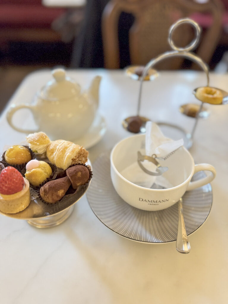Cafe table with pot of tea and tiny pastries in a famous cafe in Turin