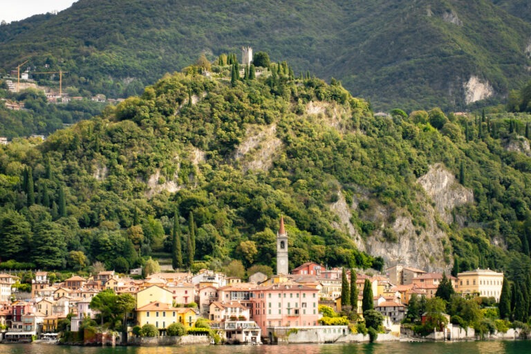 green mountains with castle and colourful village by lake como italy