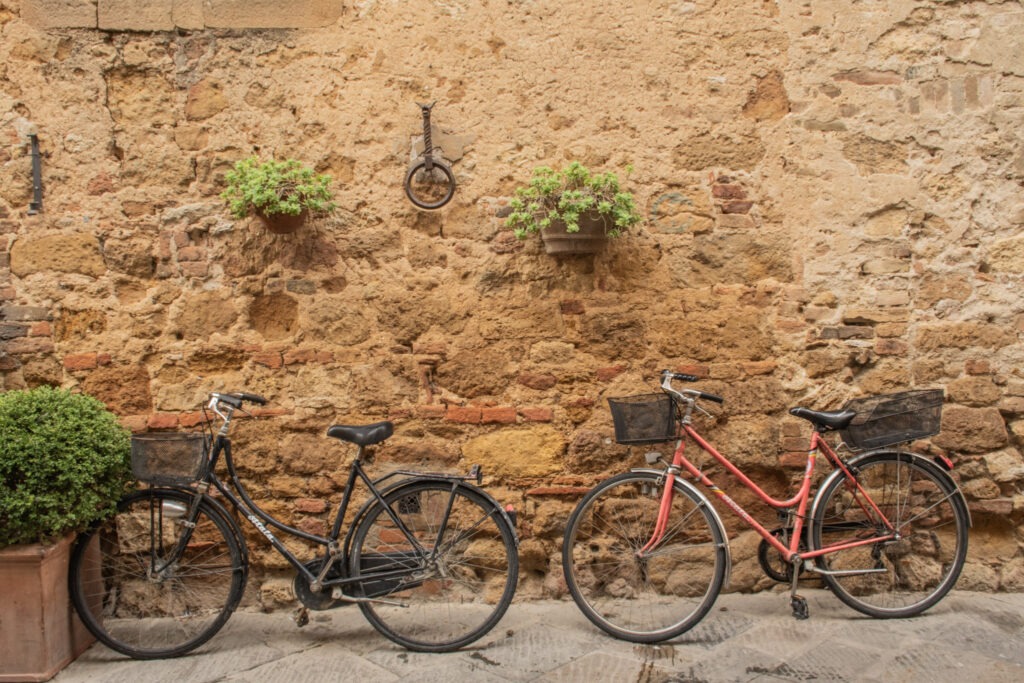 two bikes leaning against brick wall in tuscany italy