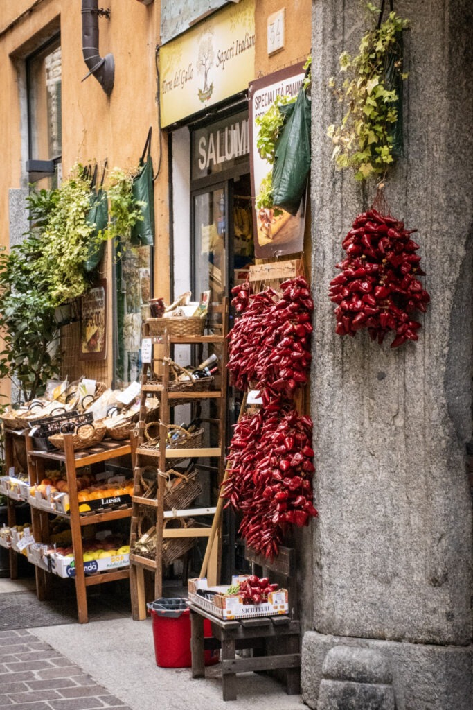market stall with red peppers hanging and fresh produce in italy