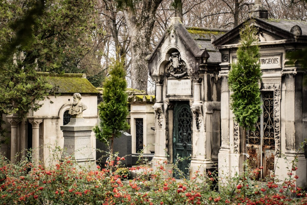 visit Père Lachaise Cemetery with above ground tombs with trees and moss