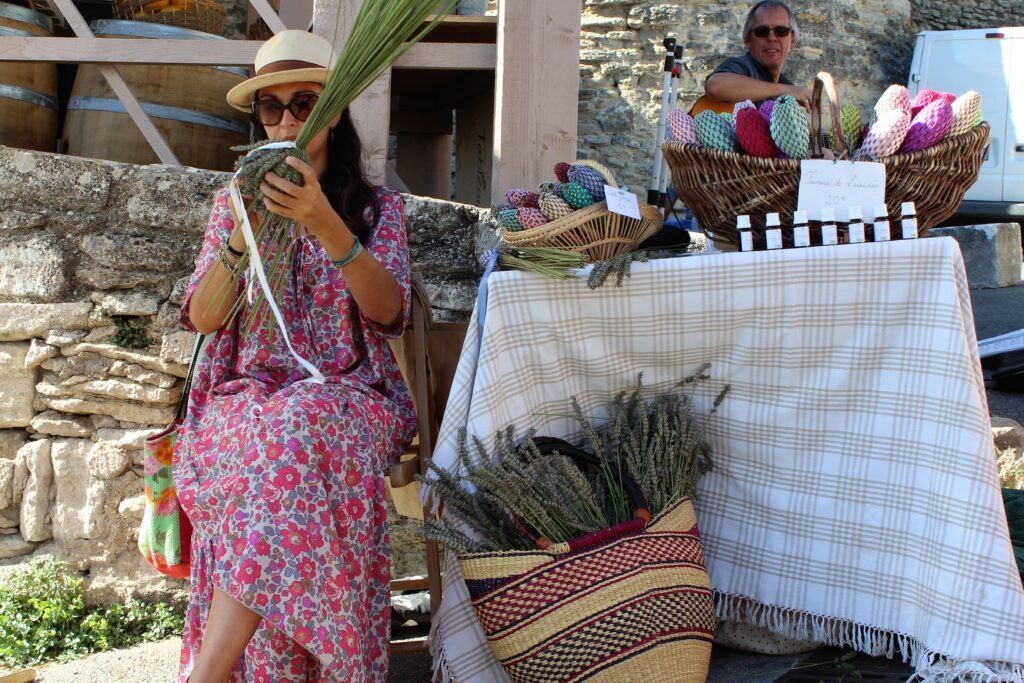 Slow Travel in France: Best Regions & How to Plan 1 women at market in France weaving lavender into a ball