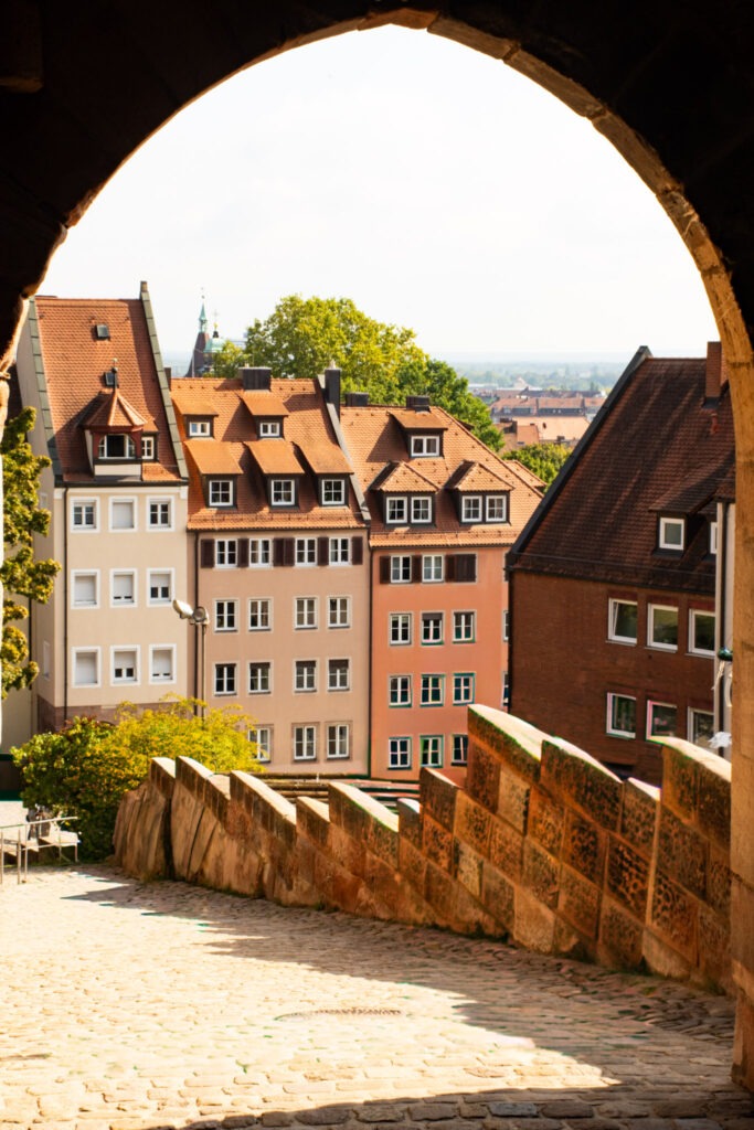 archway with cobbled stone streets and view to medieval buildings while spending one day in nuremberg