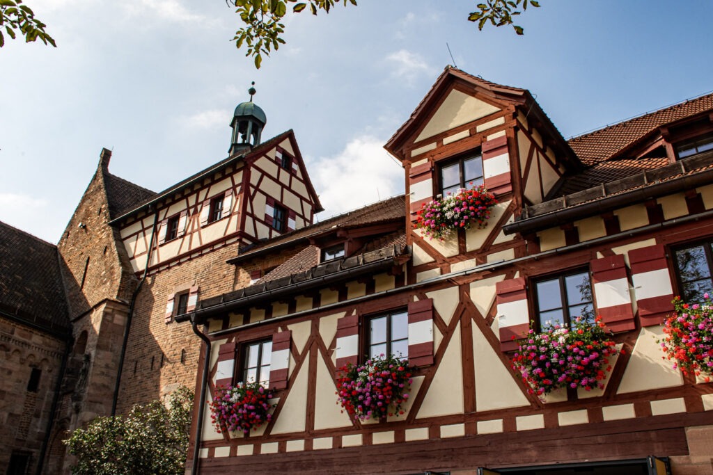 timber frame building with flower window boxes with castle while spending 1 day in Nuremberg 