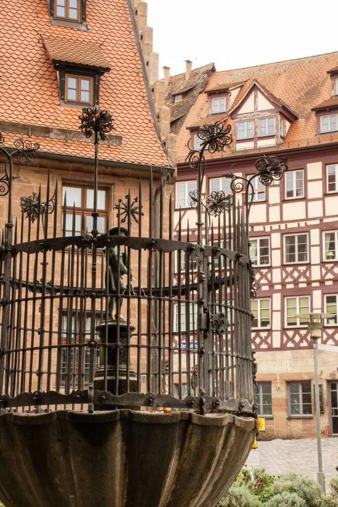 Iron lattice fountain with timberframe building in nuremberg